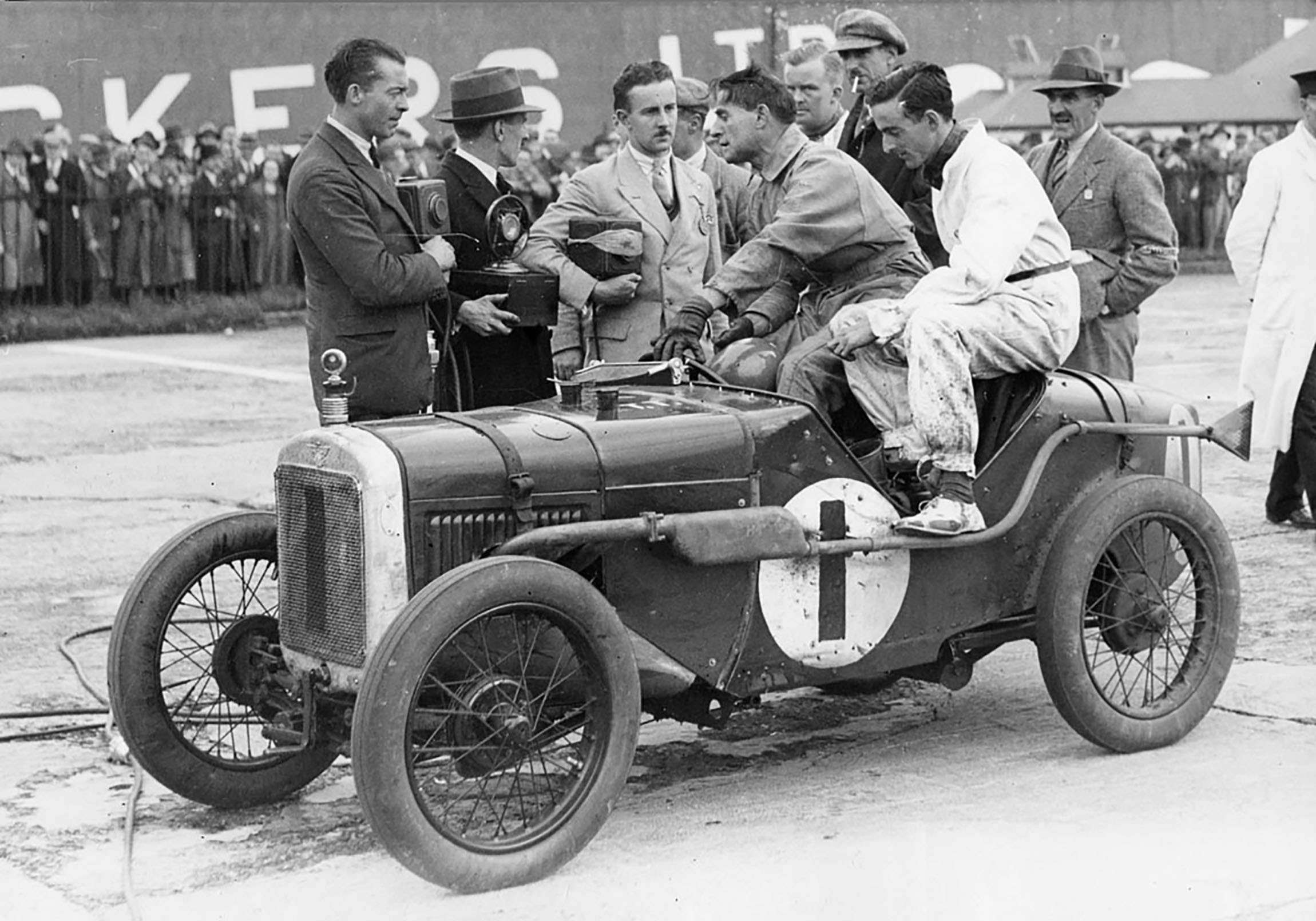 'Sammy’ Davis telling the tale after he and Freddie March had co-driven their Austin Seven to victory in the 1930 BRDC 500 at Brooklands. Davis is holding his ‘casque’ crash helmet.