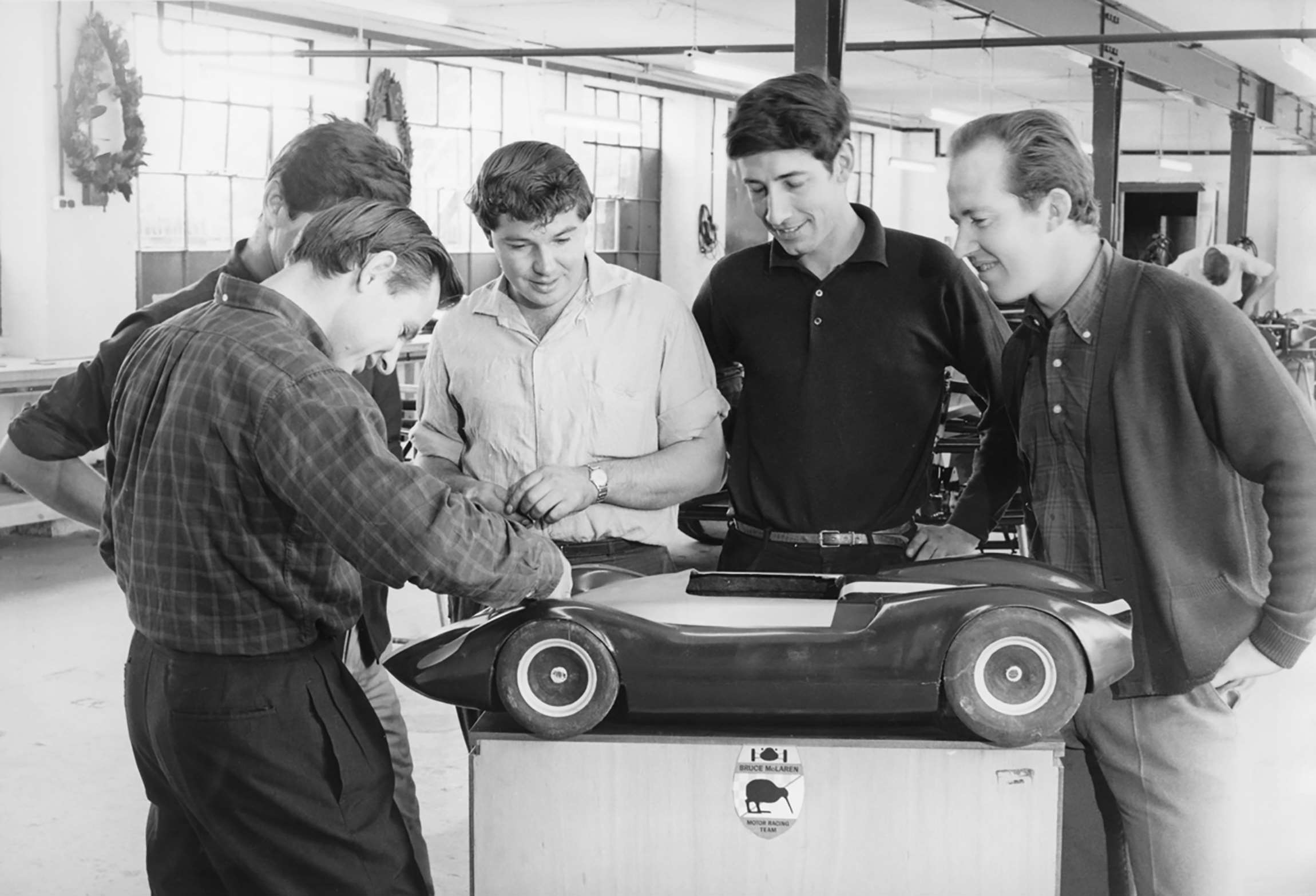 Bruce with (hidden) Wally Willmott, Bruce Harre, Howden Ganley, Eoin Young and the model new McLaren Mark 1 - Belvedere Works, Feltham, 1964.