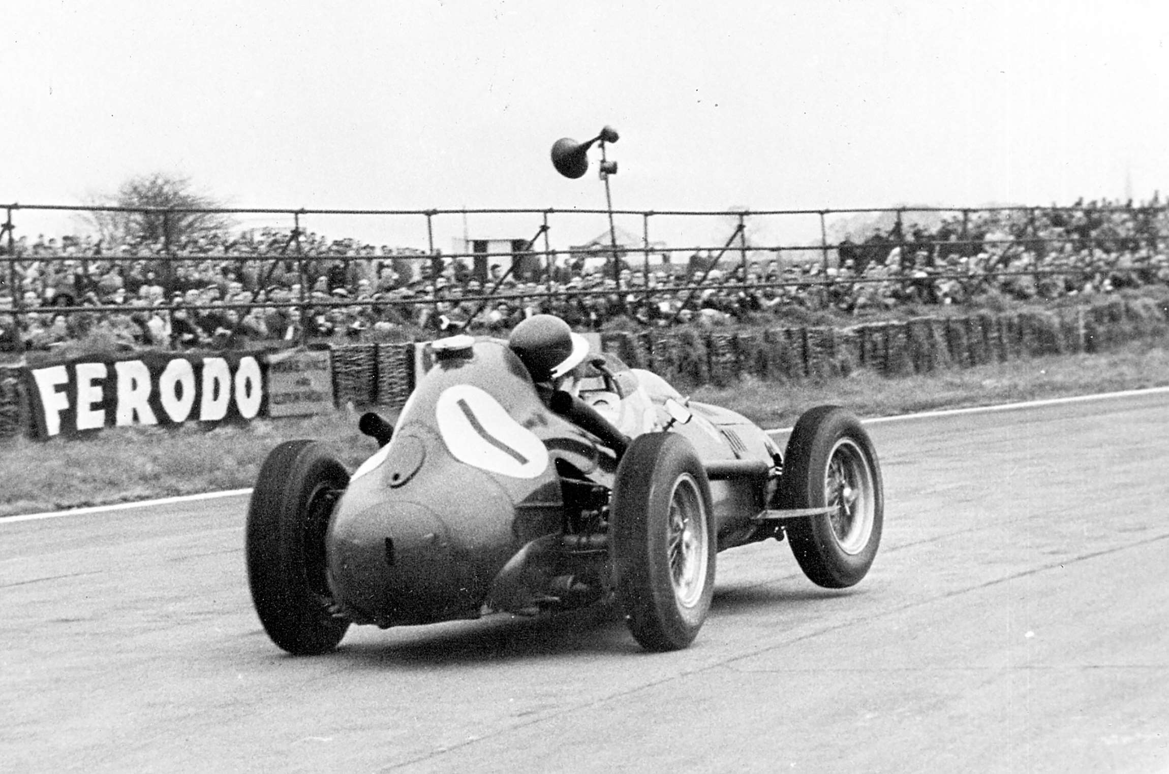 Mike Hawthorn’s wheel-waving works Ferrari Dino 246 on its winning way - 1958 Easter Monday Goodwood Glover Trophy race