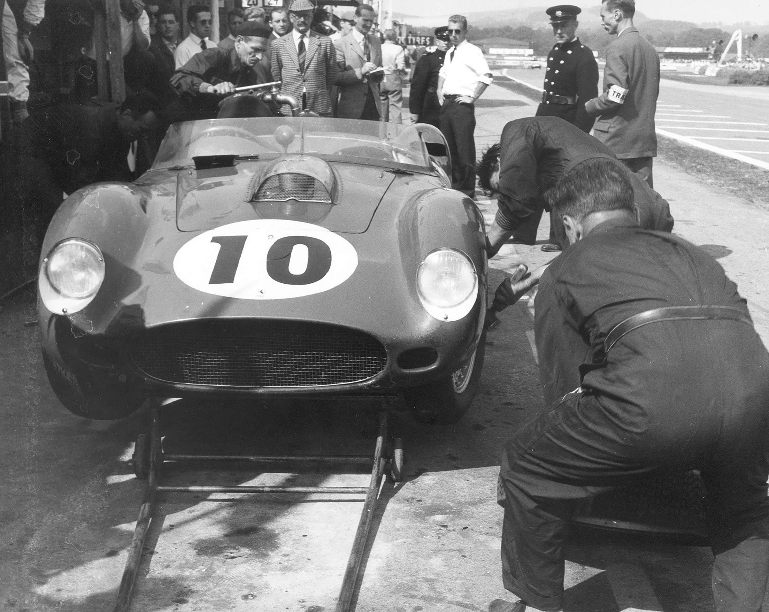 Just for once it wasn’t Ferrari who had “a Chinese fire-drill” pit-stop - this is Tony Brooks’s works Testa Rossa being fuelled just fine – see the big stop-cock handle on the filler hose… John Bolster in deer stalker, background, and the narrow grass divider strip on which Roy Salvadori landed to the right...