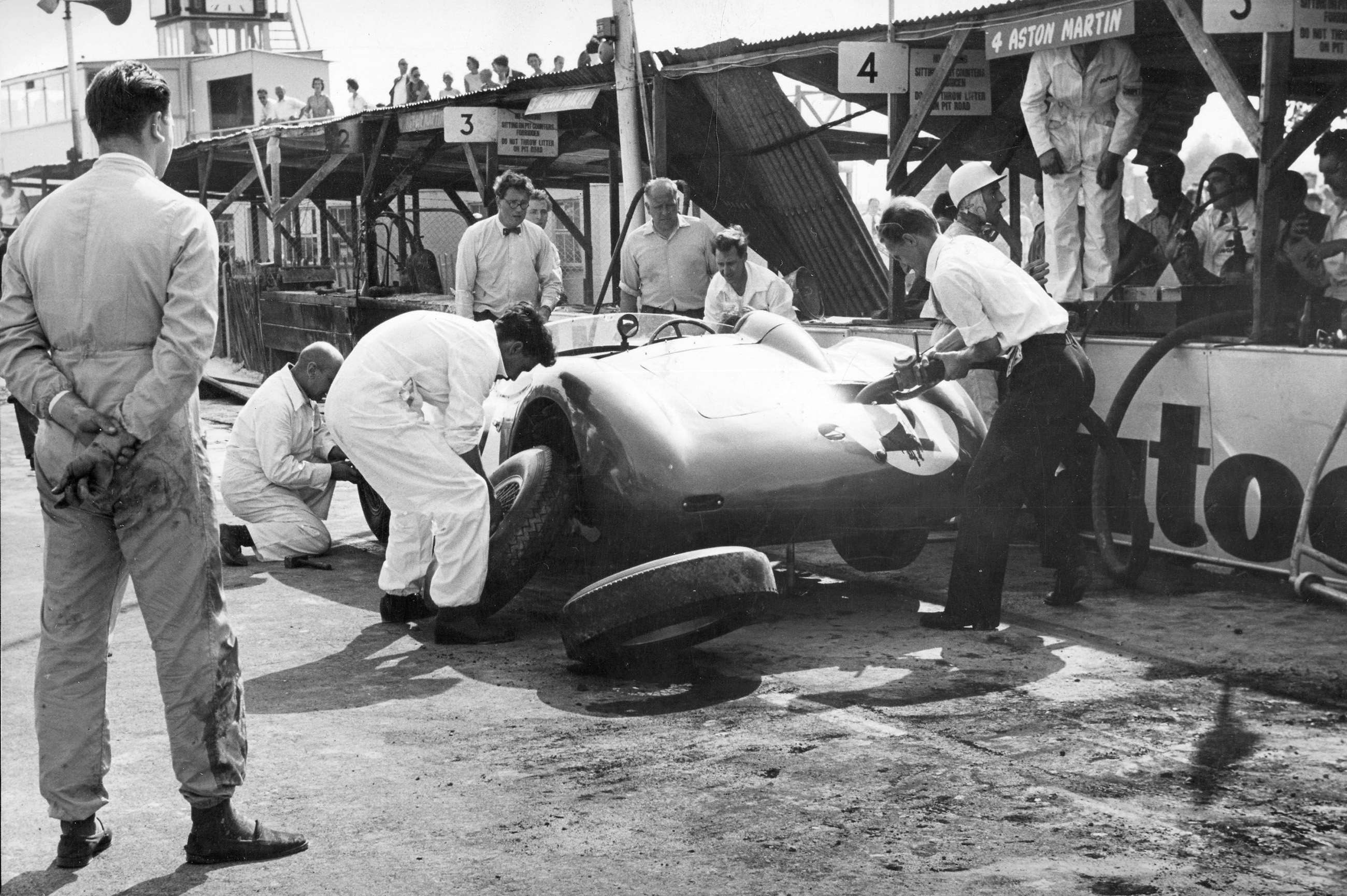 The Shelby/Fairman car which Stirling Moss took over after his own No. 1 car had been burned is seen here at its final refuelling stop - with the fire-ravaged pits self-evident - the contentious refuelling hose and its stop-cock handle can be seen clearly here.