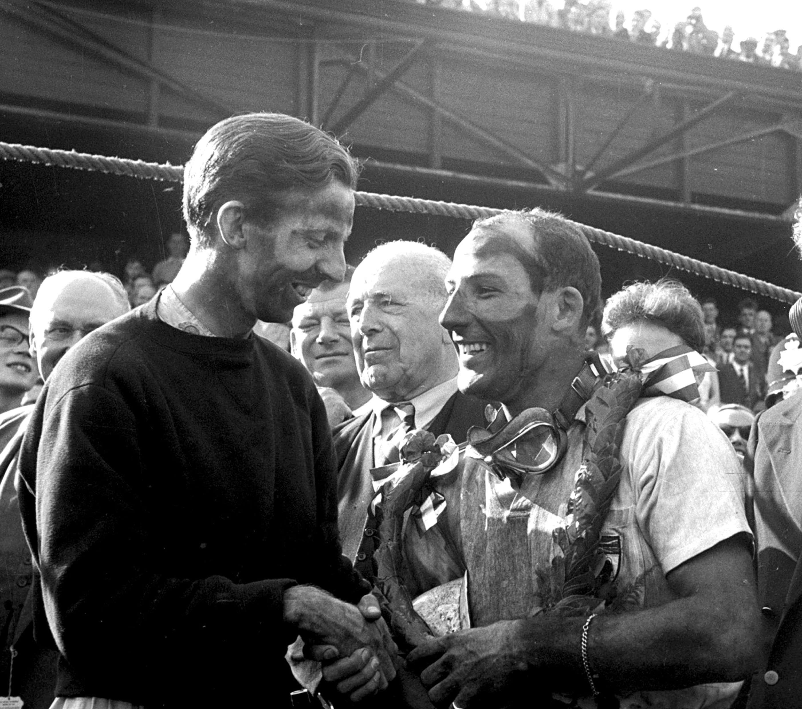 Panda pair - oil, sweat and brake dust combined coats the faces of winning duo - Tony Brooks and Stirling Moss on the 1957 British Grand Prix podium after their landmark first all-British win in a World Championship-level Grand Prix.