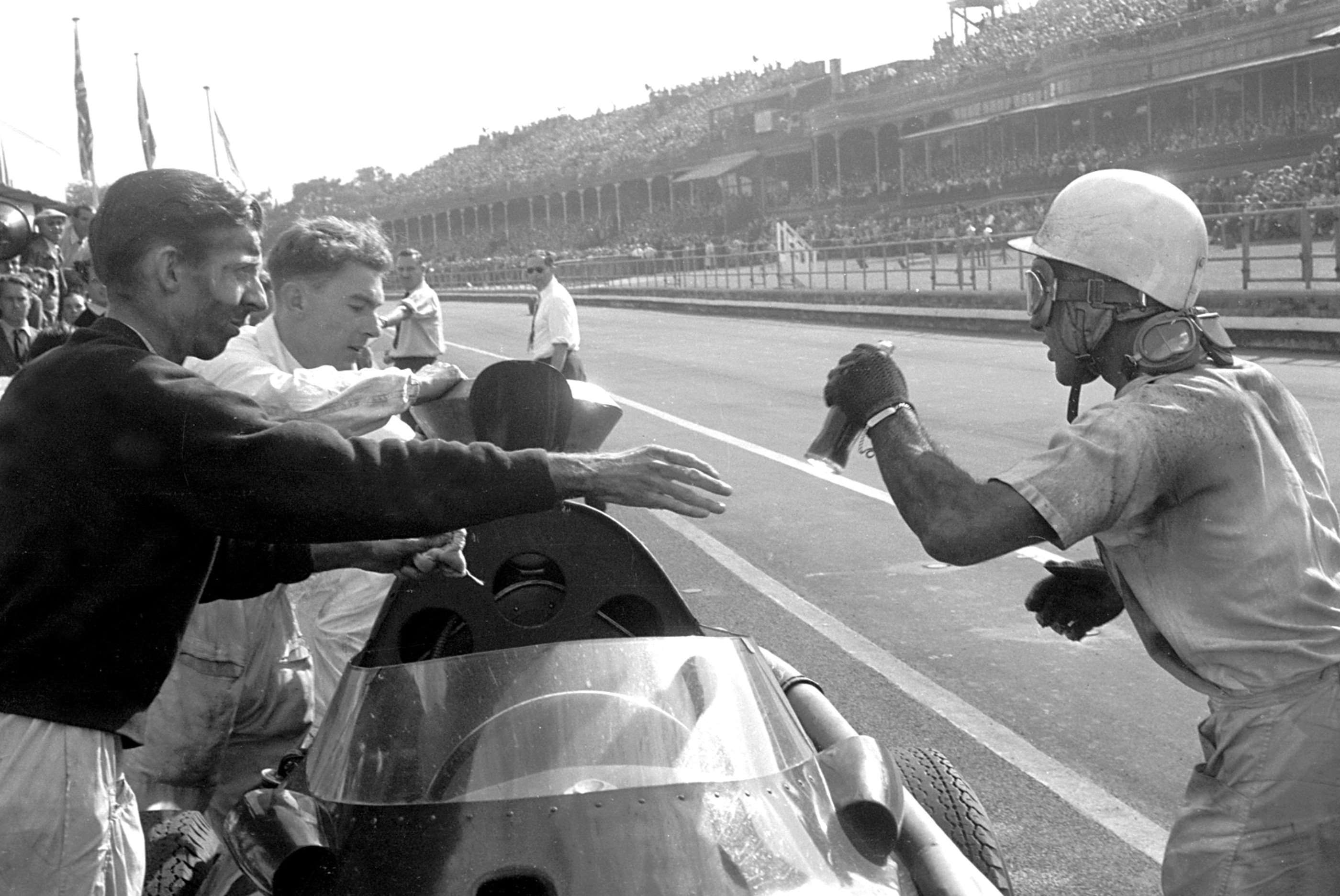 Tony Brooks hands over a drink - as well as his Vanwall car - to team-mate Stirling Moss during their crucial Vanwall pit stop at Aintree - 1957 British GP