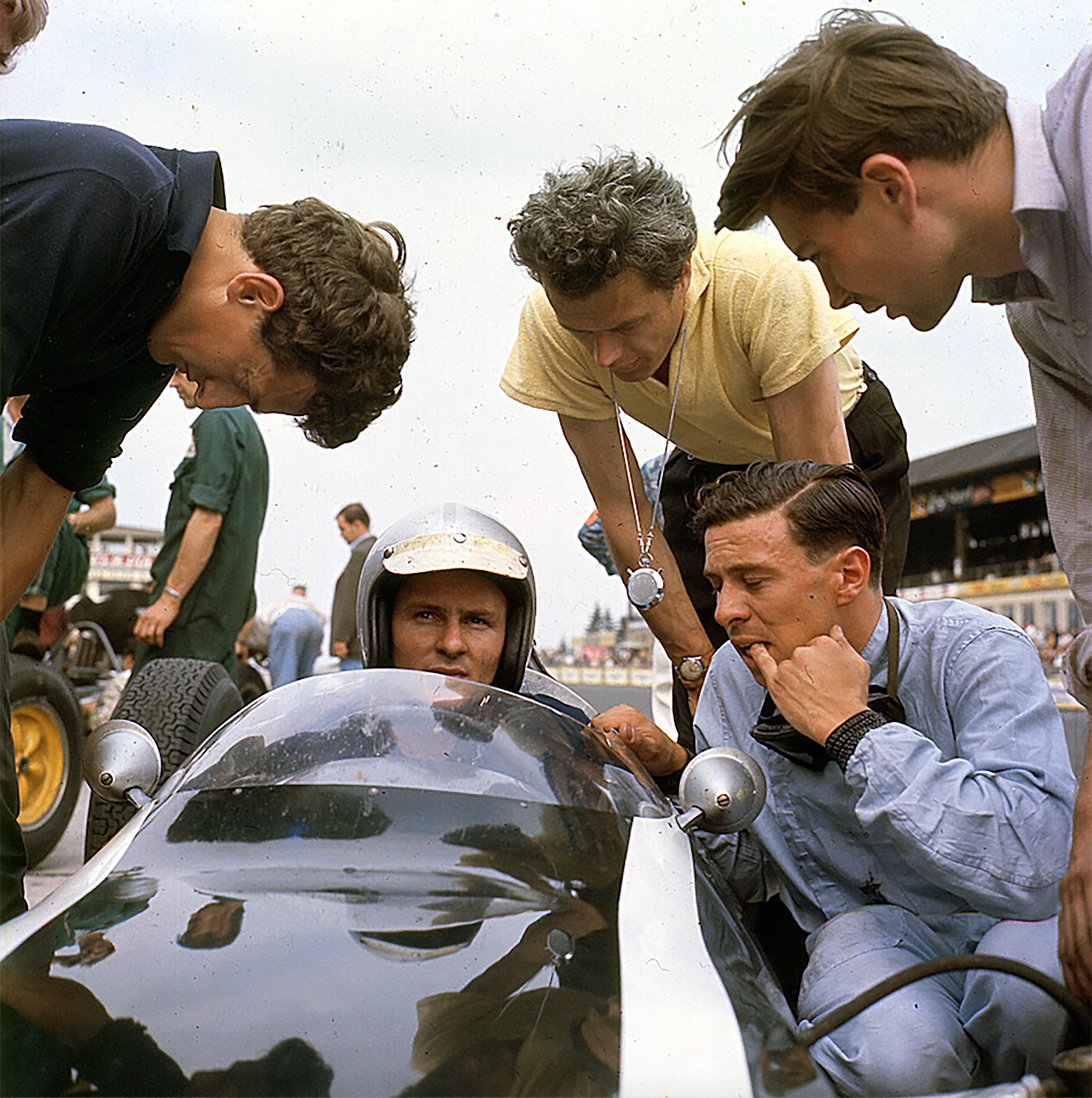Jimmy - thoughtful - with another friend yet rival Bruce McLaren of Cooper - in the pits at the Nurburgring - Cooper mechanics Noddy Grohman and Mike Barney plus (right) Lotus mechanic Allan McCall