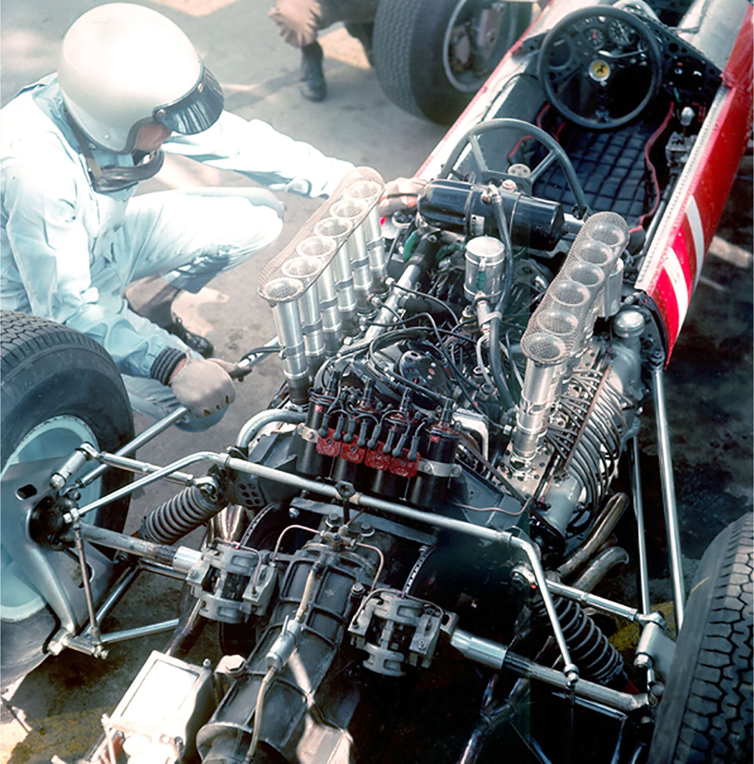 Lorenzo Bandini studying the 'Swiss watch' flat-12 cylinder engine of his Ferrari 1512 at Monaco, 1965