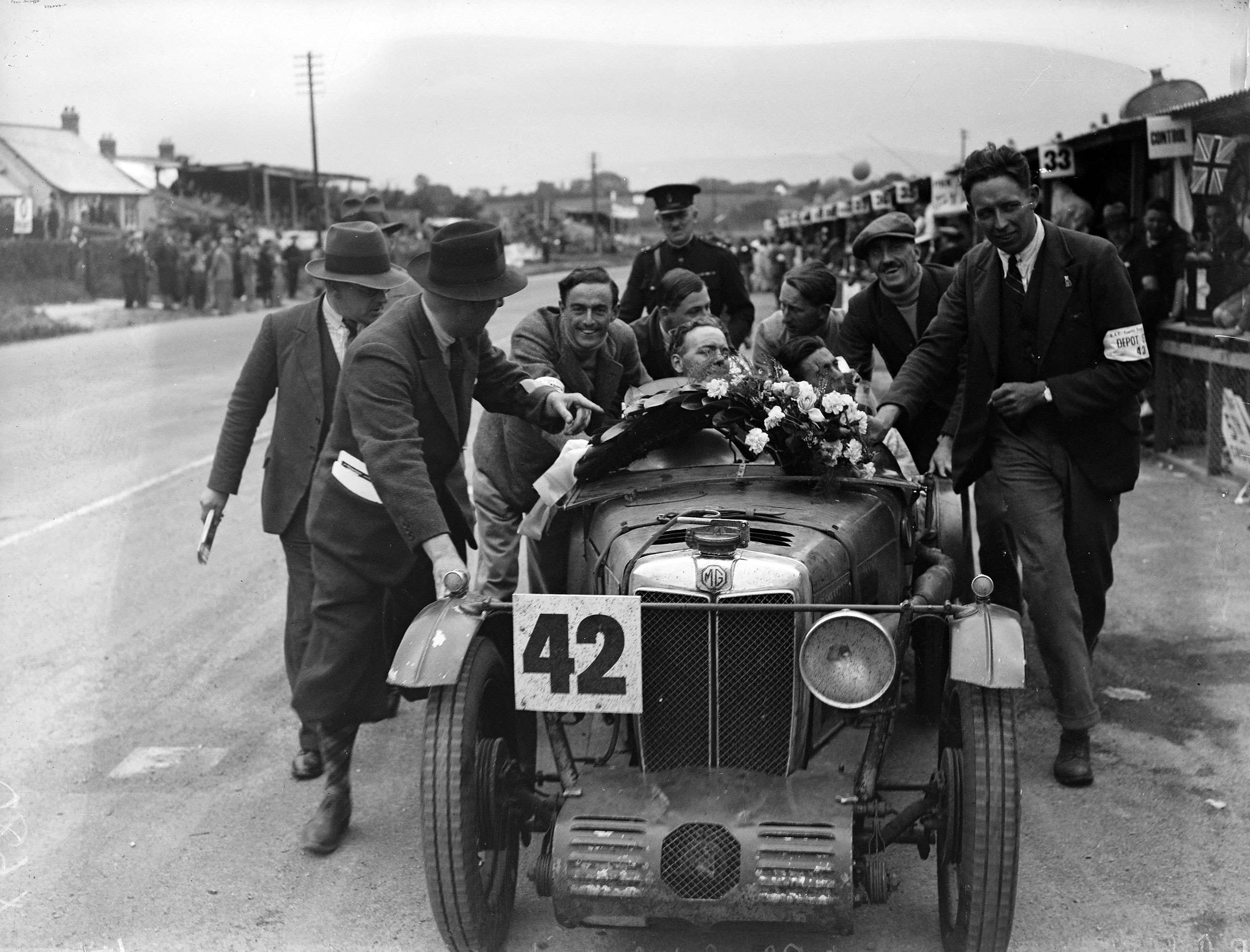 Freddie March (third from left) pushing the car of Norman Black at the Brooklands 1931 Tourist Trophy.