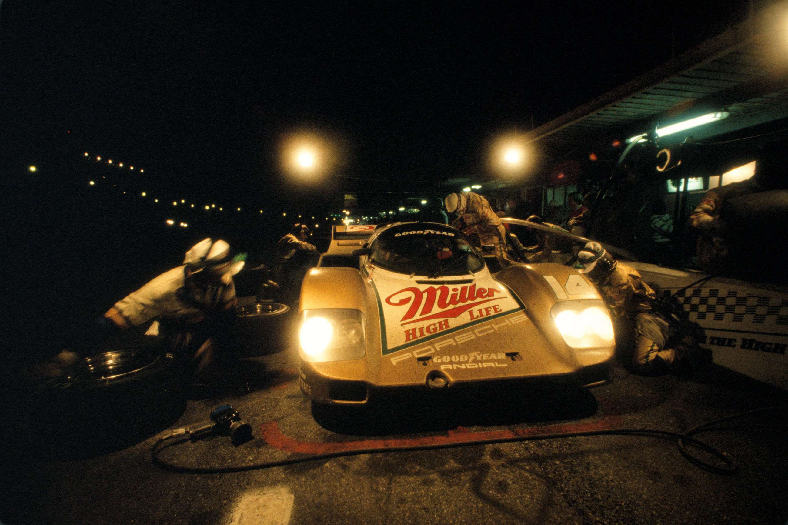 The Porsche 962 of Al Holbert, Derek Bell and Chip Robinson pits for fresh rubber and a full tank of fuel in the middle of the night.