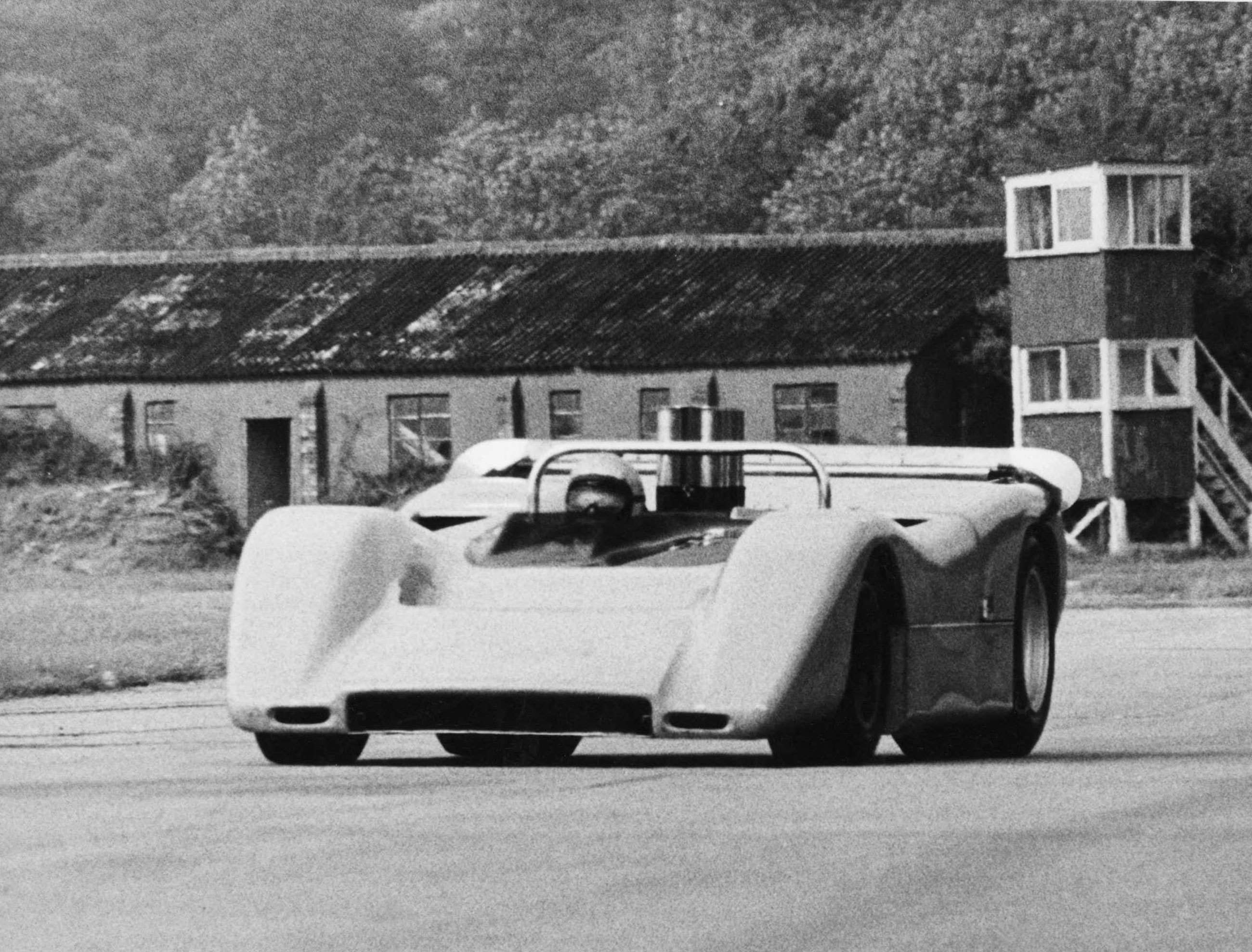 Bruce McLaren tearing past the Super Shell Building at Goodwood in a McLaren M8A.