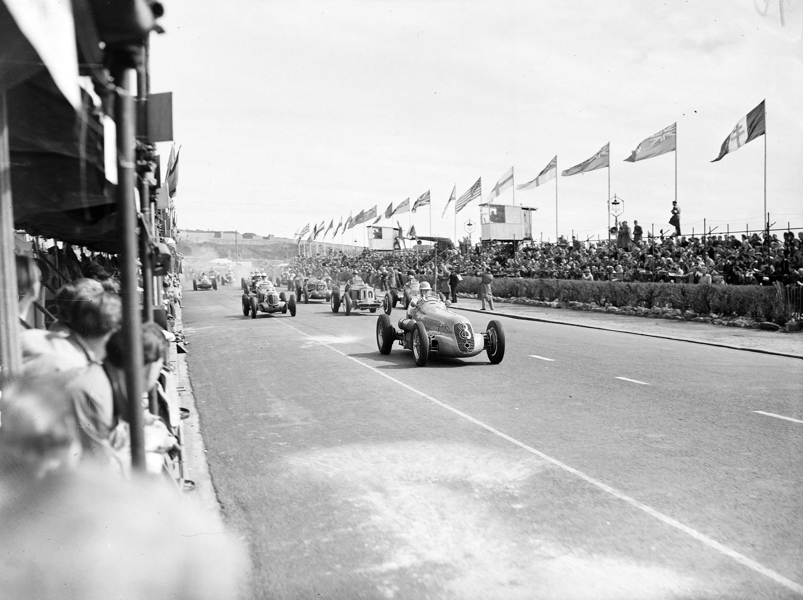 The start of the 1948 Jersey International Road Race. Red Parnell leads away in his Maserati 4CL, second is George Abecassis in a Maserati 6CM, third is Bob Gerard in an ERA B, followed by Prince Bira and Gordon Bennett.